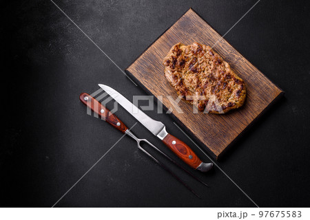 Delicious juicy grilled pork steak with spices and herbs Delicious juicy grilled pork steak with spices and herbs 97675583