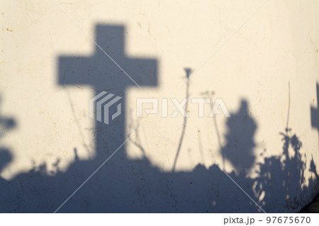 Shadow of a cross on a grave in a Greek cemetery at dawn Shadow of a cross on a grave in a Greek cemetery at dawn 97675670