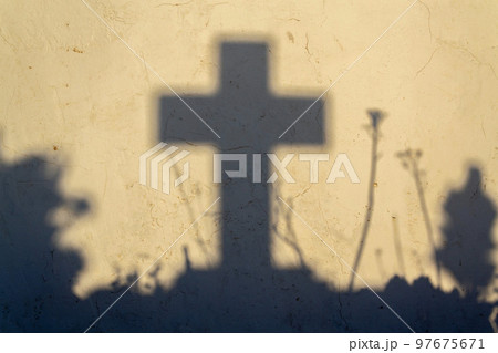 Shadow of a cross on a grave in a Greek cemetery at dawn Shadow of a cross on a grave in a Greek cemetery at dawn 97675671
