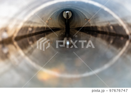 distorted water surface level view from inside a concrete culvert 97676747