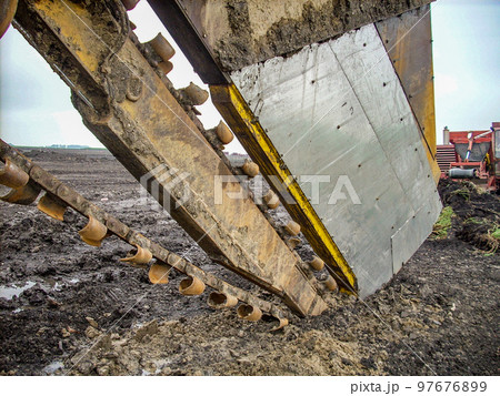 Blades and box to a field tiler trencher machine in a muddy field 97676899