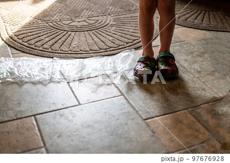 Focus on feet of a child standing on top of bubble wrap that has been popped. Focus on feet of a child standing on top of bubble wrap that has been popped. 97676928