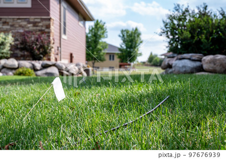 Fiber optic cable laying in the grass ready to be installed at a residential house. Fiber optic cable laying in the grass ready to be installed at a residential house. 97676939