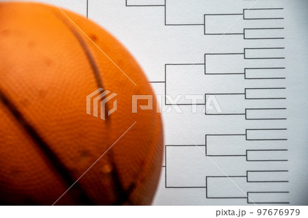 Blank bracket grid on white paper with basketball on top Blank bracket grid on white paper with basketball on top 97676979