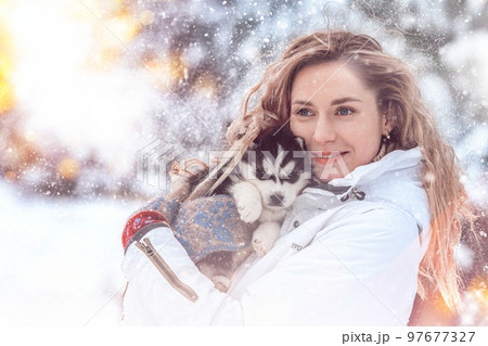 Girl playing with siberian husky in winter forest and park, animals and ecology 97677327