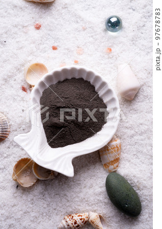 black clay around marine salt and shells background. Healthy concept black clay around marine salt and shells background. Healthy concept 97678783