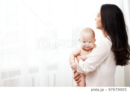 Happy mother holding and hugging adorable newborn baby 97679005