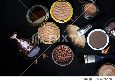 Set of bronze powder with makeup brushes on black background Set of bronze powder with makeup brushes on black background 97679270