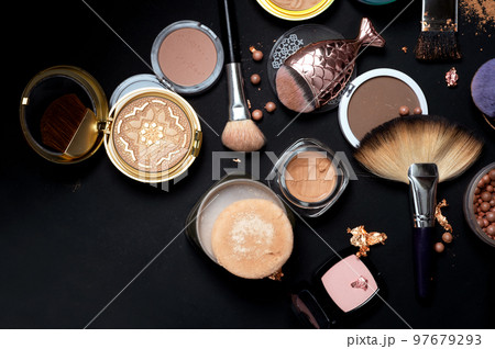 Set of bronze powder with makeup brushes on black background Set of bronze powder with makeup brushes on black background 97679293