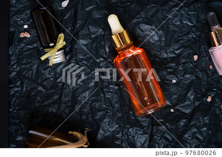 set of nature precious oils and  care cosmetics on black background . 97680026