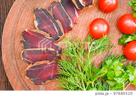 Close up of assorted sliced dry-cured meat on the wooden plate background 97680520