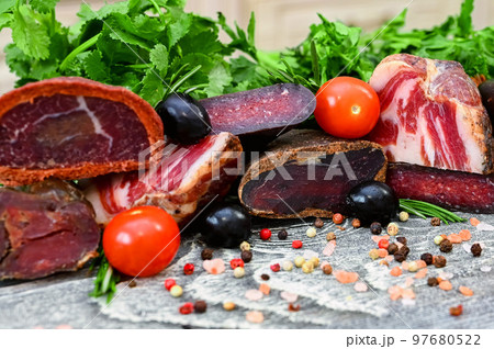 Close up of assorted dry-cured meat on the wooden background Close up of assorted dry-cured meat on the wooden background 97680522