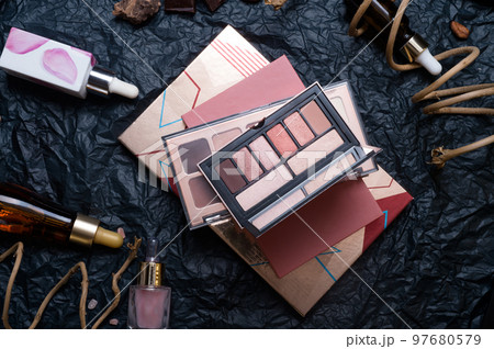 set of eye shadow palettes, cosmetics and nature chocolate on black background in frame . set of eye shadow palettes, cosmetics and nature chocolate on black background in frame . 97680579