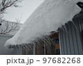 軒先からせり出す雪庇の写真素材 97682268