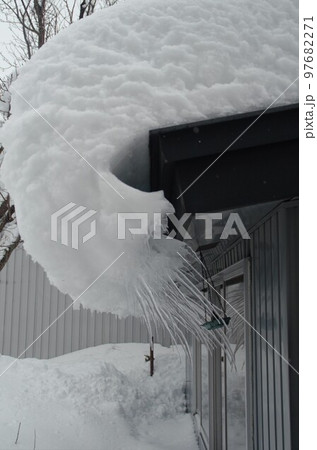 軒先からせり出す雪庇の写真素材 97682271