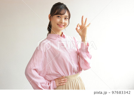 OKと腰に手を当てる若い女性1 97683342