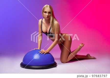 Alluring young woman in underwear lean on bosu balance ball Alluring young woman in underwear lean on bosu balance ball 97683797