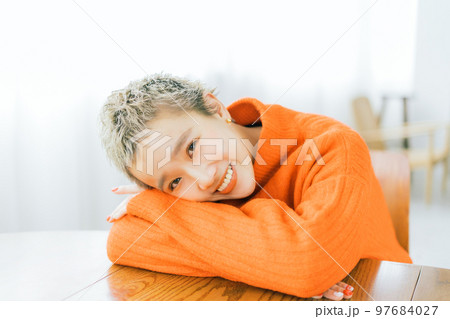 オレンジのニットを着たベリーショートの女性 97684027