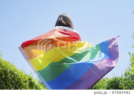虹色の旗を持った性的マイノリティの女性の後ろ姿 虹色の旗を持った性的マイノリティの女性の後ろ姿 97684482