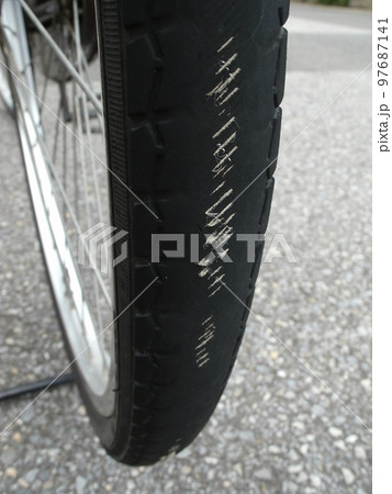 ドレッドが摩耗してタイヤのゴム内部のケーシング繊維が見えパンク寸前の自転車の車輪 ドレッドが摩耗してタイヤのゴム内部のケーシング繊維が見えパンク寸前の自転車の車輪 97687141