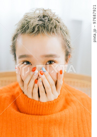 オレンジのニットを着たベリーショートの女性 97687921