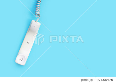 Handset of landline phone on blue background. Handset of landline phone on blue background. 97688476