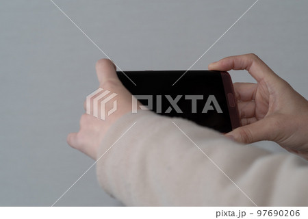 スマートフォンを持つ 97690206