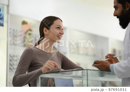 Caucasian woman choosing a new eyeglasses frame with optician. Eyesight, vision and health care concept 97691031