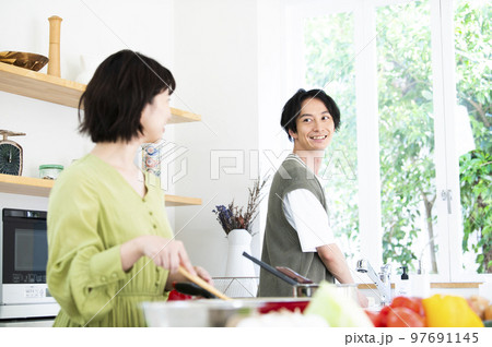 料理をする若い夫婦 97691145