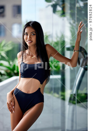 Close-Up portrait of young asian sexy girl in a black bikini posing at hotel territory 97692814