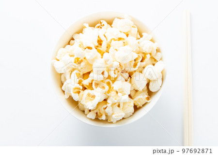 ポップコーンを箸で食べるイメージ。(白バック) ポップコーンを箸で食べるイメージ。(白バック) 97692871