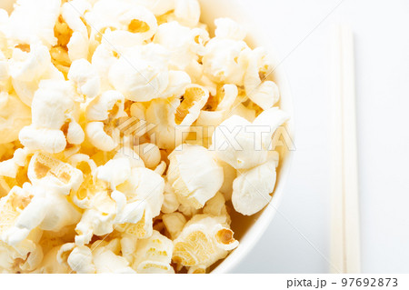 ポップコーンを箸で食べるイメージ。(白バック) 97692873