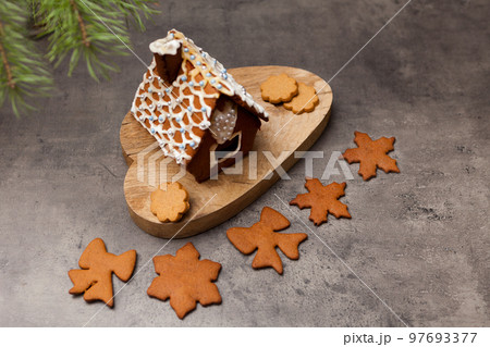 gingerbread house with cookies. Close up shot of sweet home dessert with icing decoration on gray gingerbread house with cookies. Close up shot of sweet home dessert with icing decoration on gray 97693377