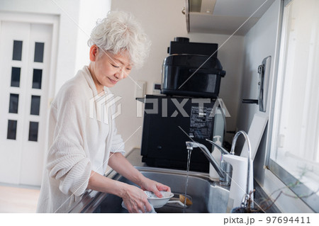 キッチンで洗い物をするシニア女性 キッチンで洗い物をするシニア女性 97694411