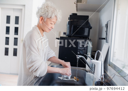 キッチンで洗い物をするシニア女性 97694412