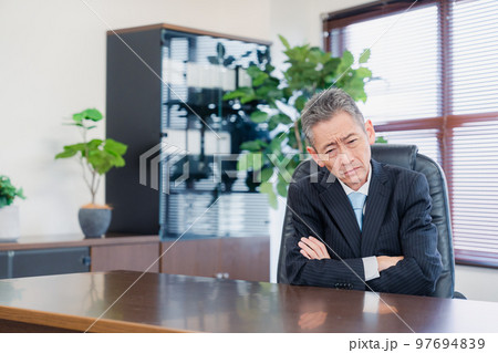 業績不振に頭を抱える経営者の男性 97694839