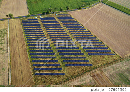 Solar panels battery in field against, aerial view. Photovoltaic modules for renewable energy. Concept of clean, sustainable, alternative energy Solar panels battery in field against, aerial view. Photovoltaic modules for renewable energy. Concept of clean, sustainable, alternative energy 97695592