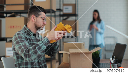 A business owner works in a warehouse with employees. The man manager is patskiing and the yellow jumper is sold, so I am an online customer. 97697412