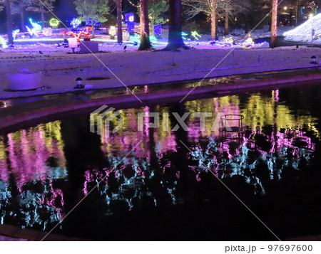 雪に浮かぶクリスマス仕様のイルミネーションと池　に映る水鏡 97697600