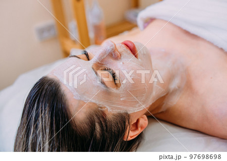 Cosmetologist makes cleansing peeling and face mask for woman. Beauty skin care 97698698