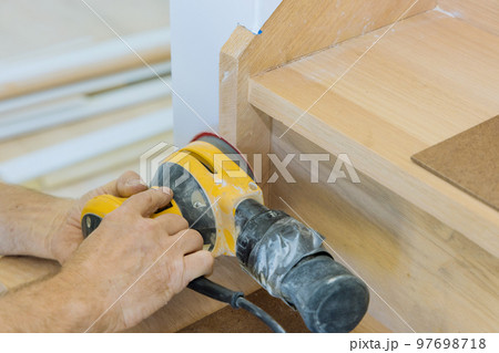 Carpeter grinding using polishing machine refinishing stairwell of railing in new home Carpeter grinding using polishing machine refinishing stairwell of railing in new home 97698718