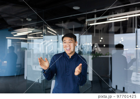 Young man Asian businessman, employee dancing in the office, celebrating victory, successful deal, monetary reward, promotion. He smiles, claps his hands. Young man Asian businessman, employee dancing in the office, celebrating victory, successful deal, monetary reward, promotion. He smiles, claps his hands. 97701425