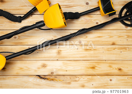 Metal detector on wooden background top view 97701963
