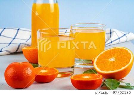 Bottle of orange juice and fresh oranges on table 97702180