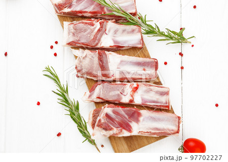 Raw meat ribs on wooden board on white background Raw meat ribs on wooden board on white background 97702227