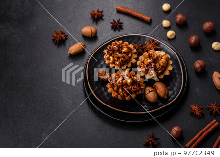 Sweet tasty tart with nuts and honey on a dark concrete background Sweet tasty tart with nuts and honey on a dark concrete background 97702349