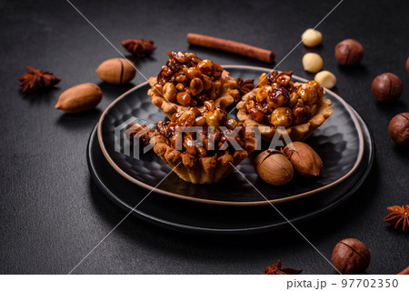Sweet tasty tart with nuts and honey on a dark concrete background Sweet tasty tart with nuts and honey on a dark concrete background 97702350