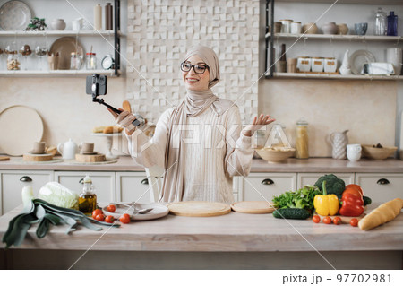 Happy young woman blogger showing to her followers how to prepare dinner with fresh vegetable Happy young woman blogger showing to her followers how to prepare dinner with fresh vegetable 97702981