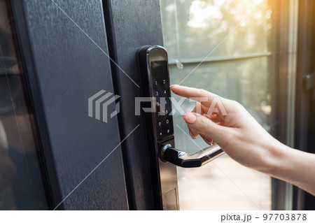 Female hand pushing the key of the free smart lock. 97703878