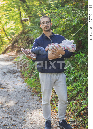 Father holding a sleeping baby in the park Father holding a sleeping baby in the park 97704111